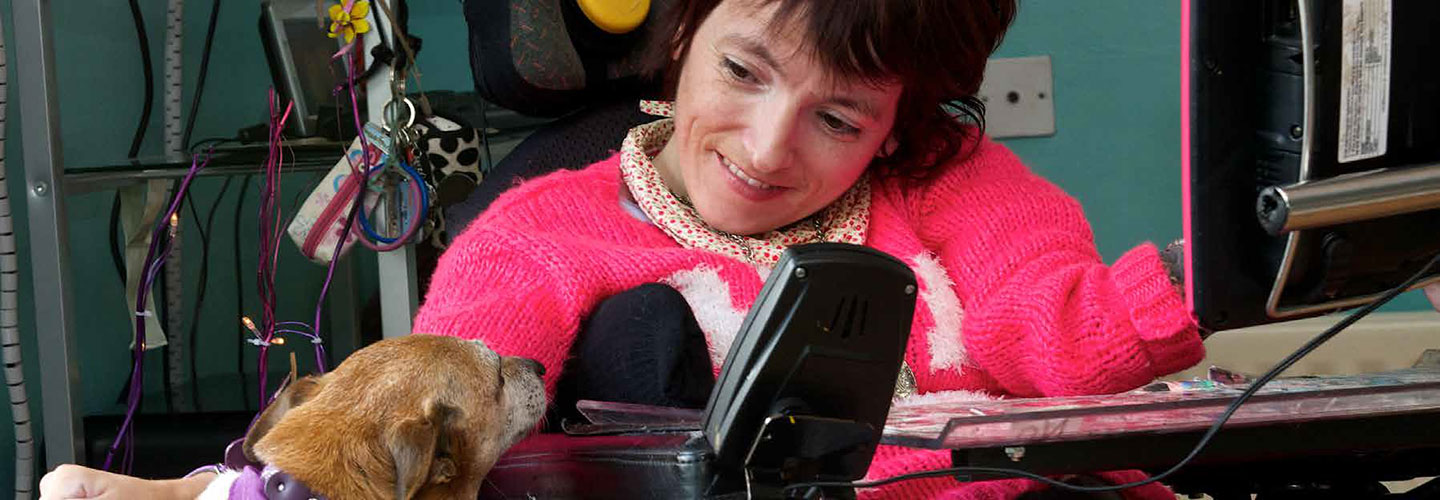 Person in an assisted wheelchair talking to a dog